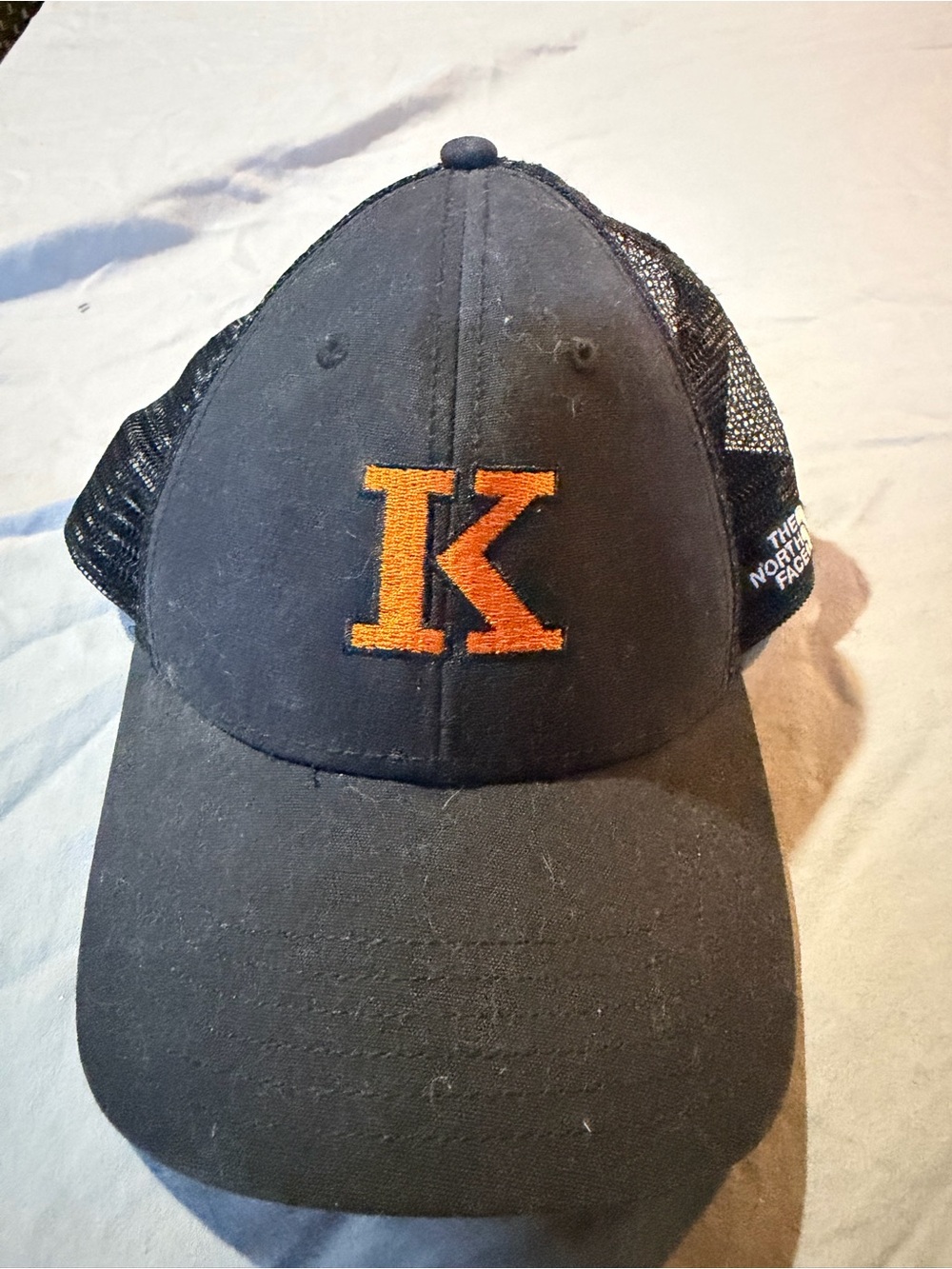 The North Face Black Mesh Trucker Cap with Orange K Embroidery